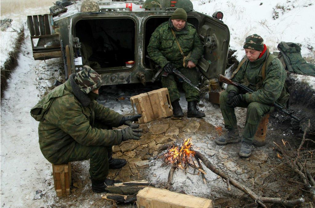 Separatisti filorussi dell'Armata Popolare di Lugansk si riscaldano attorno ad un fuoco